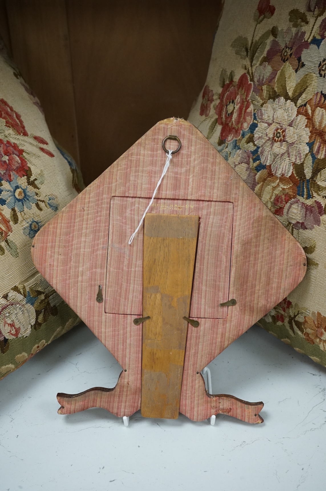An Edwardian decorative stamped gilt leather photo frame, with bow to base and a floral patterned ribbon and sequin work front panel. 27.5cm high. Condition -good